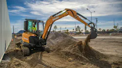 An operator using a CASE mini excavator on a job site.