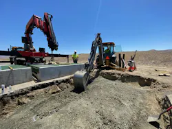 Crews using construction equipment to repair a cattle guard.